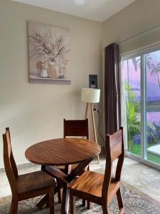 ein Esszimmer mit Tisch und Stühlen und einem Fenster in der Unterkunft Casa Arizona in Brisas de Zicatela