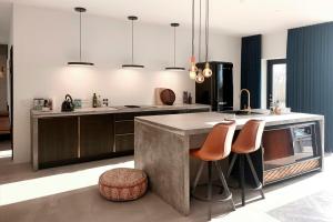a kitchen with a large island with bar stools at Hotel Vibe In Architectural Settings in Årre