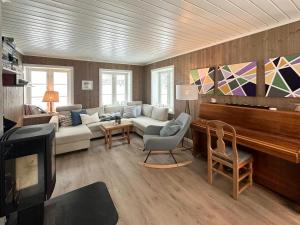 a living room with a couch and a piano at Charming Farm From 1600S In Stunning Surroundings in Treungen