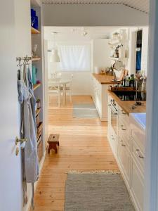 a kitchen with white cabinets and a wooden floor at Cosy, Undisturbed Sanctuary Away From The City in Nykøbing Sjælland