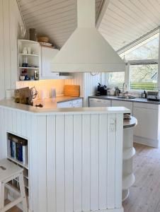 a white kitchen with a white island in a room at Family House In Two Homes At Fyns Head in Martofte