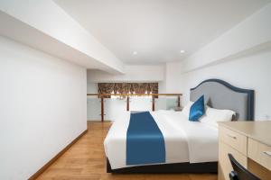 广州Guangzhou Youke Serviced Apartment1min to Line5 Taojin STN-Free shuttle bus during the Canton Fair的卧室配有一张蓝色色调的大型白色床。