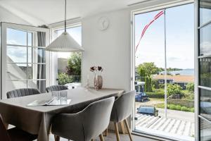 a dining room with a table and chairs and a large window at Enjoy Møn From Historic House in Stege +24 photos