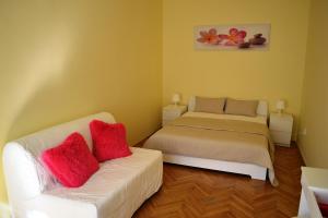 プラハにあるSunflower 2BDR Flat By Ruterraのベッドルーム1室(ベッド1台、白いソファ、赤い枕付)