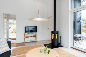 Una sala de estar con chimenea y una mesa. en Seaside Cabin With Ocean View And Sunny Terrace, en Søgne