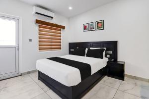 una camera con un letto bianco e nero e una finestra di Super Collection O Munnar a Anachal