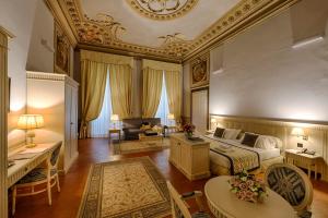 a bedroom with a king sized bed and a living room at Palazzo Guicciardini in Florence