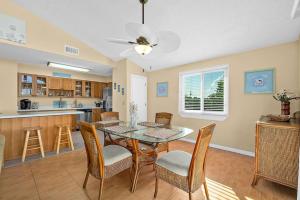 Una cocina y un comedor con mesa y sillas. en Bungalow with Pool, en Ormond Beach