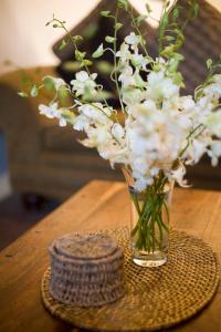 a vase of white flowers sitting on a table at Gallery Apartments in Warrnambool