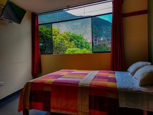 a bedroom with a bed and a large window at Hostal El Bosque in Huánuco