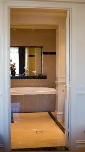 a bathroom with a tub and a large mirror at Gallery Apartments in Warrnambool