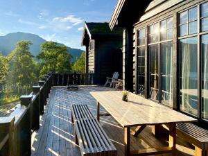 a wooden deck with a table and benches on a house at Timber Cabin With Fantastic View In Oppdal in Oppdal