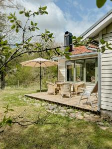 Un patio con una mesa y sillas y una sombrilla. en Delight For The Soul In Österlen's Nature, en Gärsnäs