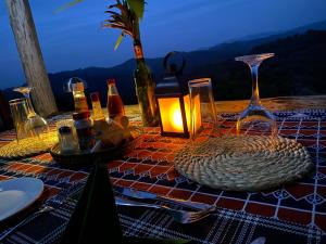 a table with a table cloth with a candle on it at Bwindi Neckview Lodge in Buhoma