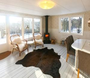 Una sala de estar con mesa y sillas y una chimenea. en Delight For The Soul In Österlen's Nature, en Gärsnäs