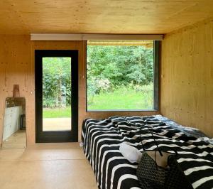 een bed in een kamer met een groot raam bij Japanese-Inspired Nature Gem In Vejby Strand in Vejby