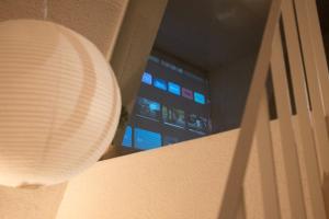 a white lamp hanging on a wall next to a window at Soansosa Duplex of designer in Bucheon