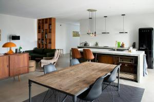 a kitchen and living room with a wooden table and chairs at Hotel Vibe In Architectural Settings in Årre