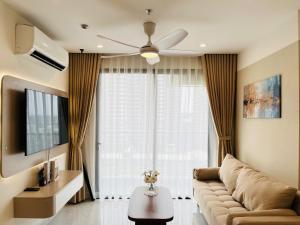 un salon avec un canapé et un ventilateur de plafond dans l'établissement May Homes - 3PN BS8 Tropiacal Vinhomes Grand Park, à Long Bình