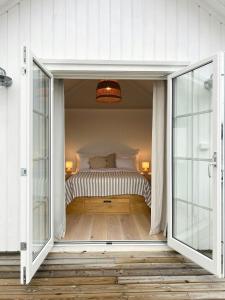 a bedroom with a bed through a sliding glass door at Modern & Charming Summer House Near Risør in Søndeled