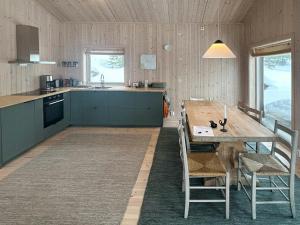 a kitchen and dining room with a wooden table at Fantastic Forest Cabin With Panoramic View in Jaren