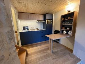 a kitchen with blue cabinets and a wooden table at Charmant Duplex in Saint-Didier-au-Mont-dʼOr