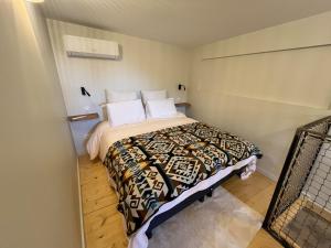 a bedroom with a bed with a comforter and pillows at Charmant Duplex in Saint-Didier-au-Mont-dʼOr