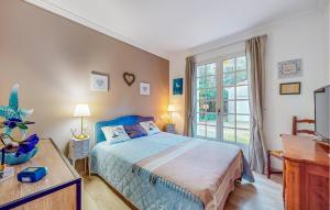 ein Schlafzimmer mit einem blauen Bett und einem Fenster in der Unterkunft Amazing Home In Meschers-Sur-Gironde in Meschers-sur-Gironde