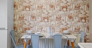 HardingstoneにあるSpacious 3-Bed Home Near M1, Sky TV & Netflix Included 2x Parking Spaces Garden Fast Wifi Contractors Travellers Relocators Leisure Welcomeの椅子2脚と動物の壁紙が付いたテーブル