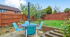 HardingstoneにあるSpacious 3-Bed Home Near M1, Sky TV & Netflix Included 2x Parking Spaces Garden Fast Wifi Contractors Travellers Relocators Leisure Welcomeの裏庭のパティオ(テーブル、椅子付)