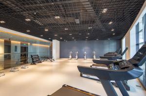 una palestra con una fila di cyclette in una stanza di 青岛西海岸城市阳台Madison酒店 a Qingdao