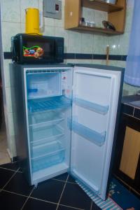 a refrigerator with its door open in a kitchen at Classic Studio Bamburi in Mombasa