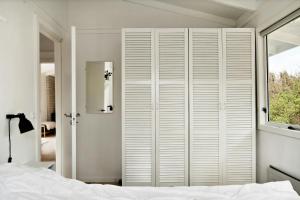 a bedroom with a white closet and a bed at Bright And Cozy Cottage Close To The Sea in Hornbæk