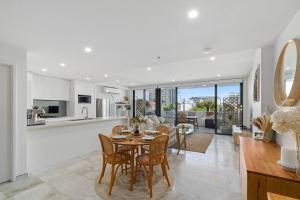 a kitchen and living room with a table and chairs at Crown Beach Escape - Stylish Comfort by the Sea in Wollongong