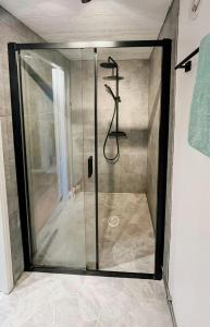 a shower with a glass door in a bathroom at Stonecutter's Cottage In Scenic Lysekil in Lysekil