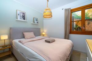 a bedroom with a bed with pink sheets and a window at Casa Vista Bonita in Port de Soller