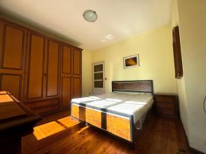 a bedroom with a bed in a room with wooden floors at Appartamento centro Sondrio in Sondrio