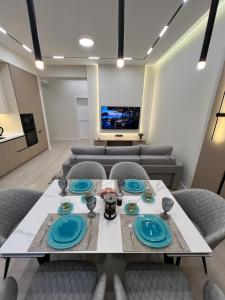 a dining room with a table and chairs and a tv at PA- premium apartments in Bukhara