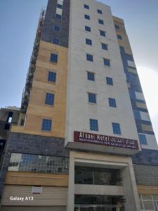 a tall building with a sign on it at فندق الساعي Alsai Hotel in Al ‘Utaybīyah