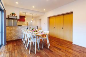 een keuken en eetkamer met een tafel en stoelen bij 美ら海水族館まで車で5分 広い庭 最大10名 まるまる貸し切り 花の雲 in Motobu +74 foto's