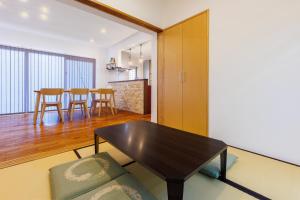een woonkamer met een tafel en een eetkamer bij 美ら海水族館まで車で5分 広い庭 最大10名 まるまる貸し切り 花の雲 in Motobu