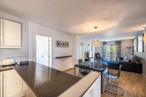 a kitchen and living room with a table and a couch at Paloma Beach Apartments in Los Cristianos
