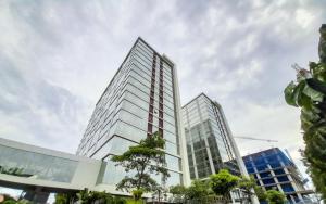 dos edificios altos de cristal en una ciudad en Best Choice and Modern Studio at Mataram City Apartment By Travelio, en Kejayan