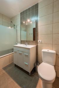 a bathroom with a toilet and a sink and a mirror at Paloma Beach Apartments in Los Cristianos