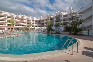 a large swimming pool in front of a hotel at Paloma Beach Apartments in Los Cristianos