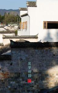 un muro di mattoni con una croce sopra di Standing in the wild a Xiwu