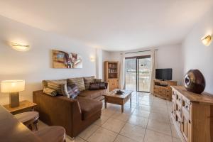 a living room with a couch and a tv at Paloma Beach Apartments in Los Cristianos