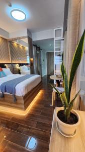 马尼拉Air residence Fantasy Sophisticated Heaven on earth Gym Swim Park 300 MB的卧室里有一张床，桌子上放着一盆盆栽