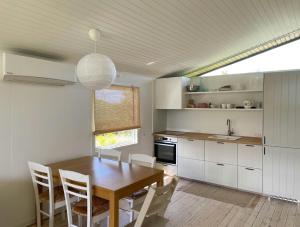 een keuken met een houten tafel en witte kasten bij Home With Nordic Interior in Korsør