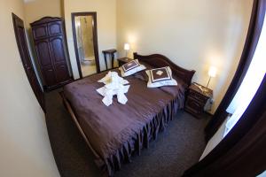 a bedroom with a large bed with purple sheets and pillows at Penzión Altmayer in Banská Štiavnica